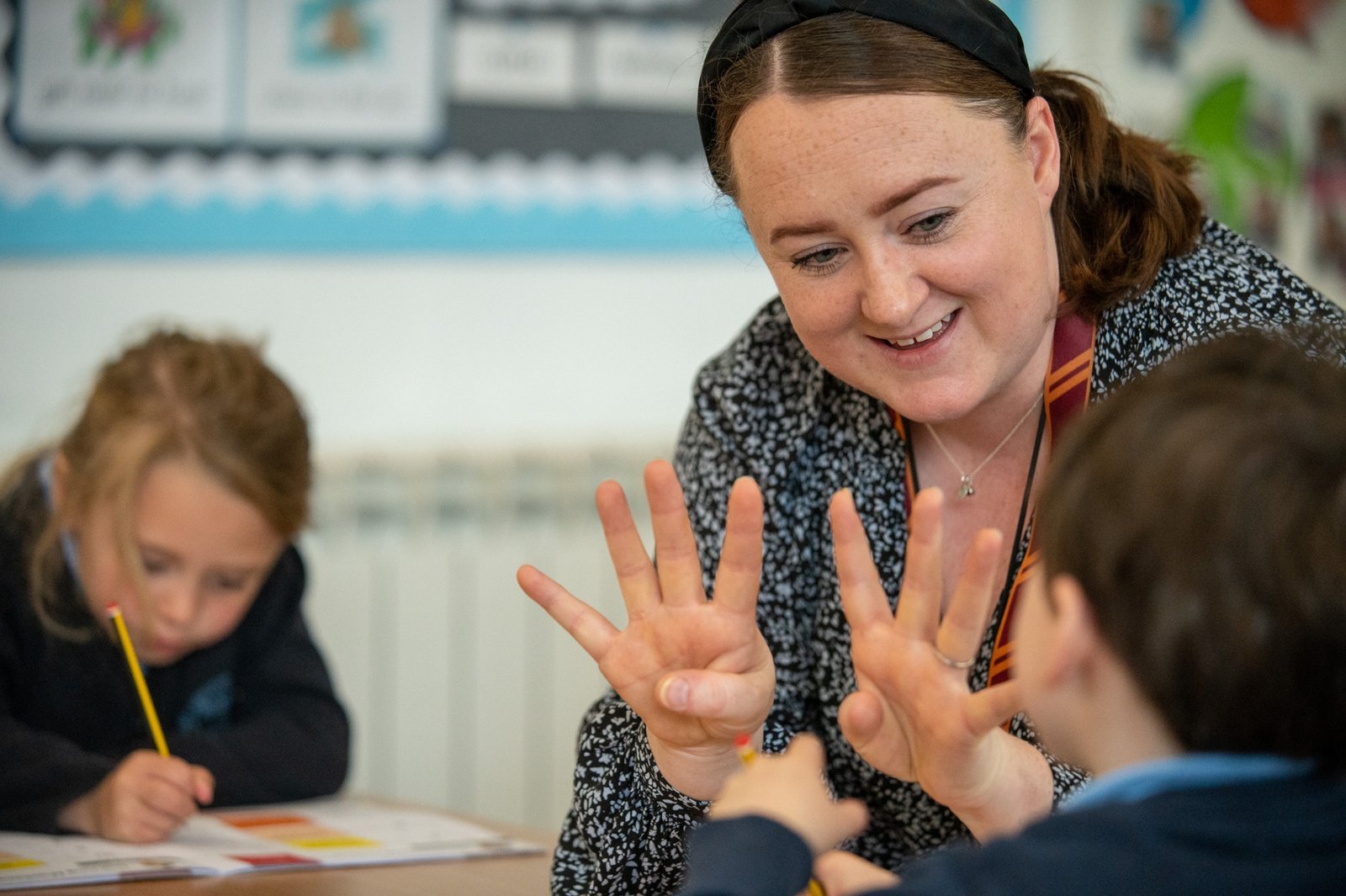 A teacher and primary pupils working through a learning activity
